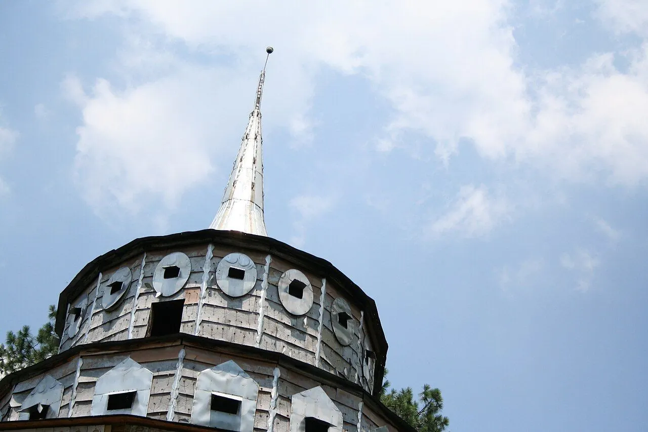 Folk art structures and painted signs in a garden