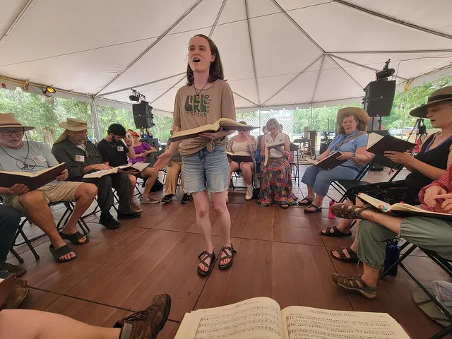 Singers seated in a hollow square with tunebooks